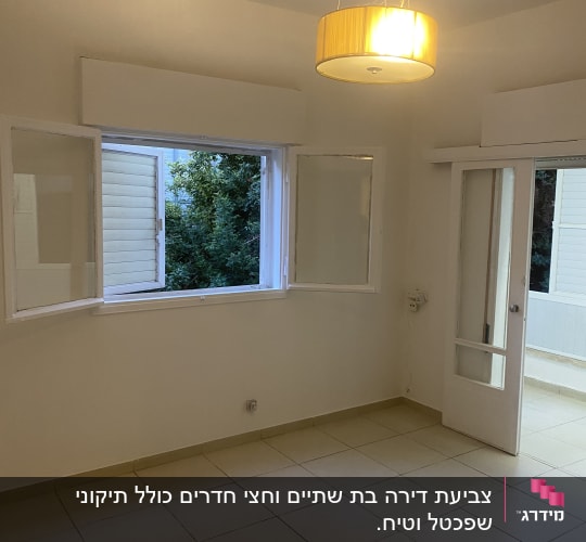 חדר ריק עם קירות צבועים בלבן ותאורה תלויה